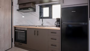 Eine moderne Küche mit Einbauofen, Kaffeemaschine und Kühlschrank.