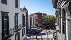 A street view with buildings, a clear sky, and pedestrians. - Zarco Suites by Sé Funchal (Funchal)