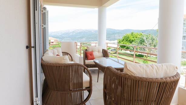 A balcony with wicker furniture, a glass table, and a view of mountains. - Apartment Eliana - 3 brms - 1st floor - Building B (Fokata)