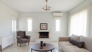 A living room with a fireplace, a sofa, a chair, and a coffee table. - Apartment Eliana - 3 brms - 1st floor - Building B (Fokata)