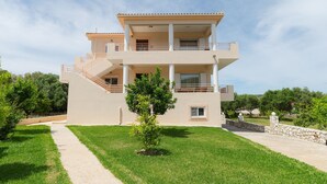 A two-story building with a balcony, a small garden, and a stone wall. - Apartment Eliana - 3 brms - 1st floor - Building B (Fokata)