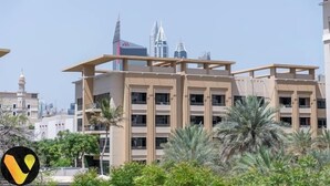 Un immeuble à plusieurs étages doté d’une architecture moderne, avec des balcons et un toit plat.