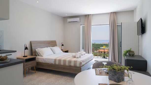 Een moderne slaapkamer met een bed, nachtkastjes, een televisie en een balkon met uitzicht.