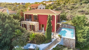 A Mediterranean-style villa with a swimming pool, stone walls, and lush greenery. - Villa Levanda in Matsoukata (Matsoukata)