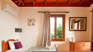 A bedroom with a wooden bed, a dresser, a mirror, and a window with curtains. - Villa Levanda in Matsoukata (Matsoukata)