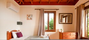 A bedroom with a wooden bed, a dresser, a mirror, and a window with curtains. - Villa Levanda in Matsoukata (Matsoukata)