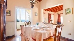 Comedor con una mesa dispuesta para cuatro personas, un candelabro y vistas a través de un ventanal.