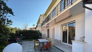 A patio with a table and chairs, a white wall, and a window. - Apartment in a semi-detached house with independent entrance.-Rif. Casa Nina (San Vincenzo)