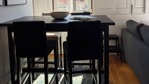 A dining area with a table, chairs, and a view of buildings through a window. - Charming apartment in the center of Porto! Lots of sunshine and a garage available. (Porto)