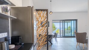 Eine moderne Küche mit Einbauherd, Kaffeemaschine und einem dekorativen Holzpaneel.