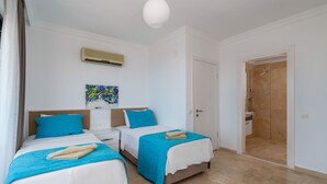 Ein Hotelzimmer mit zwei Betten, einer Dusche und einem Bild an der Wand.