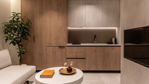 Een moderne keuken met houten kastjes, een wit aanrechtblad en een inbouwoven.