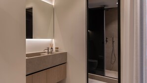 Een moderne badkamer met een grote spiegel, een wastafel en een douchecabine.