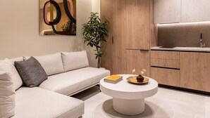 Een moderne woonkamer met een bank, een salontafel en een keuken met houten kasten.