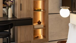 Une chambre moderne avec un meuble en bois, un bureau et un luminaire suspendu.