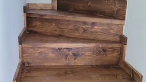 Eine Holztreppe mit rustikalem Design, gefertigt aus dunklen Holzbrettern.