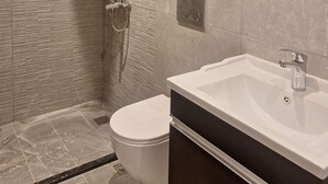 A modern bathroom with a shower, toilet, and sink.