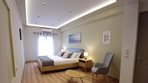 A modern bedroom with a bed, bedside tables, a chair, and a small round table.