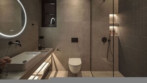 A modern bathroom with a large mirror, a shower, and a toilet.