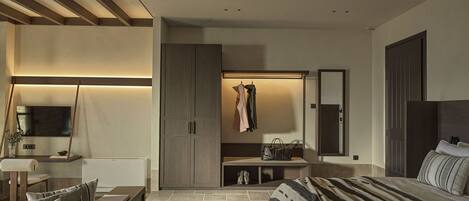 Un dormitorio moderno con cama, zona de estar, armario y ventilador de techo.