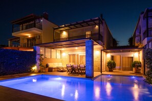 A modern two-story house with a swimming pool, outdoor seating, and a covered patio area. - Sunny Exclusive Dio in Chaniotis (Chaniotis)