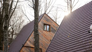 Ein modernes Haus mit Satteldach und einem großen Fenster.