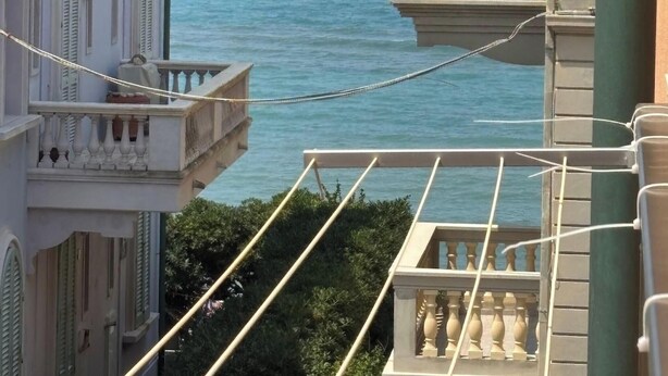Blick auf ein Küstengebäude mit Balkonen, die auf das Meer blicken.