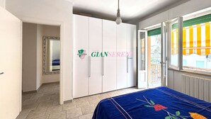 Ein Schlafzimmer mit Bett, Kleiderschrank und Blick ins Freie.