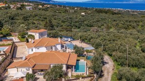 Una villa con piscina, rodeada de olivares y vistas al mar.