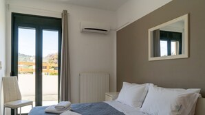 Hotellihuone, jossa on sänky, tuoli, ikkuna ja patteri.