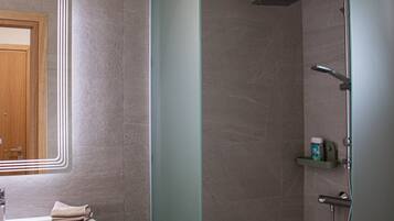 A bathroom with a shower, a sink, and a mirror.