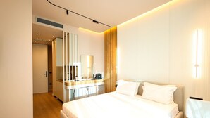 Ein modernes Hotelzimmer mit einem großen Bett, einem Nachttisch, einem Spiegel und einer Wandpaneele aus Holz.
