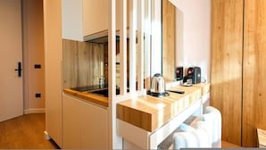 Eine moderne Küche mit Holzausstattung, einem Einbauherd und einer Kaffeemaschine auf der Arbeitsplatte.
