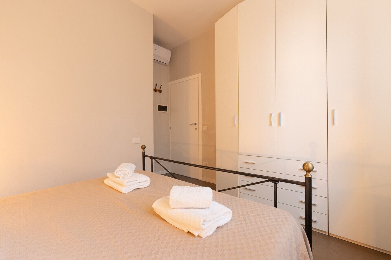Ein Hotelzimmer mit einem Bett, einem Kleiderschrank und einem Badezimmer im Hintergrund.