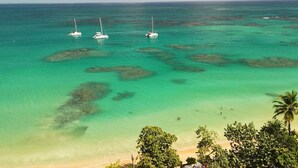 A coastal view with clear turquoise waters, boats, and a beach with palm trees. - Private Pool Villa | Parking | Washer (Las Terrenas)
