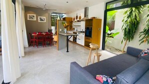 A modern living room with a sofa and a dining area with a table and chairs. - Private Pool Villa | Parking | Washer (Las Terrenas)