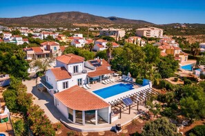 A residential area with modern houses, a swimming pool, and a mountain in the background. - Novo Amanha in Deerfield Beach (Quelfes)