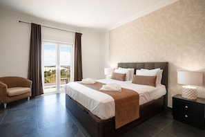 A hotel room with a large bed, a sofa, a nightstand, and a view of the outdoors. - Novo Amanha in Deerfield Beach (Quelfes)