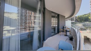 Ein Balkon mit Blick auf eine Baustelle, einem Tisch mit Stühlen und einem Blumentopf.