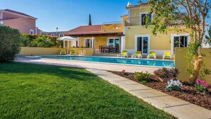 A residential property with a swimming pool, a well-maintained lawn, and a patio area with outdoor furniture. - Amapola in Quelfes with 4 bedrooms and 4 bathrooms (Quelfes)