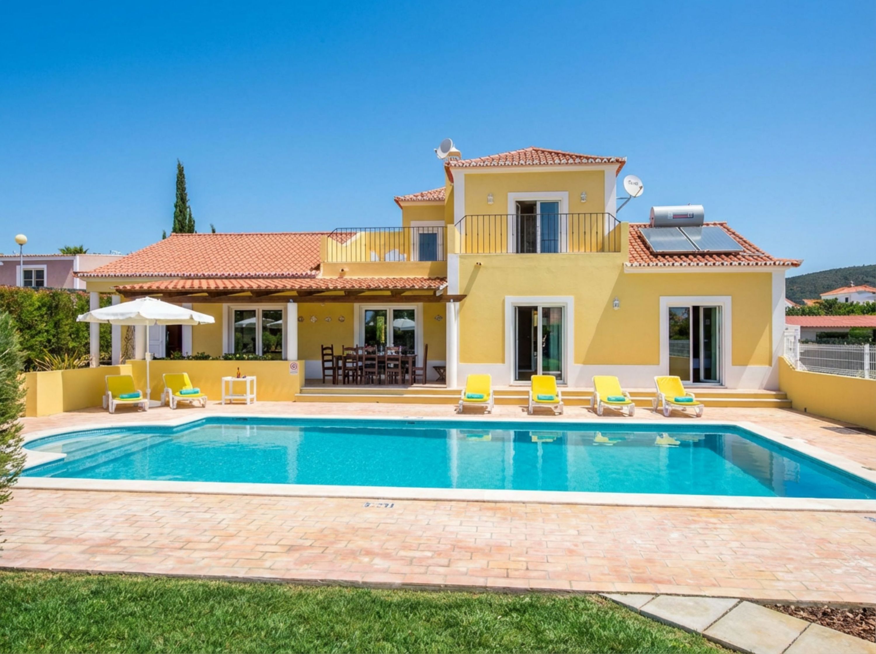 A two-story house with a swimming pool, outdoor furniture, and a satellite dish.