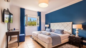 A bedroom with a bed, bedside tables, a desk, a TV, and a window with curtains. - Amapola in Quelfes with 4 bedrooms and 4 bathrooms (Quelfes)