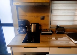 Een koelkast, een oven, een kookplaat, een koffiezetapparaat/waterkoker