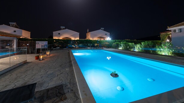 A swimming pool at night with a clear view of the moon and adjacent buildings. - Τριαντάφυλλο/Rose near to sea with heating pool (Mavrovouni)