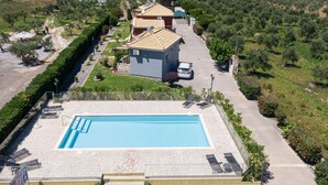 Un espace piscine comprenant des chaises longues et une piscine.
