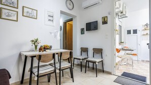 Un coin repas avec une table, des chaises et une horloge au mur.