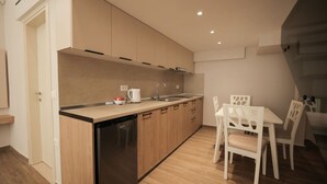 A modern kitchen with wooden cabinets, a dishwasher, and a dining area with white chairs and a table.