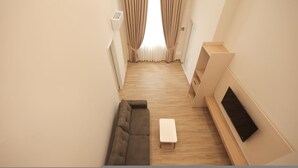 A modern living room with a sofa, a coffee table, and a TV mounted on the wall. - Duplex City 05 in Durrës (Durrës)