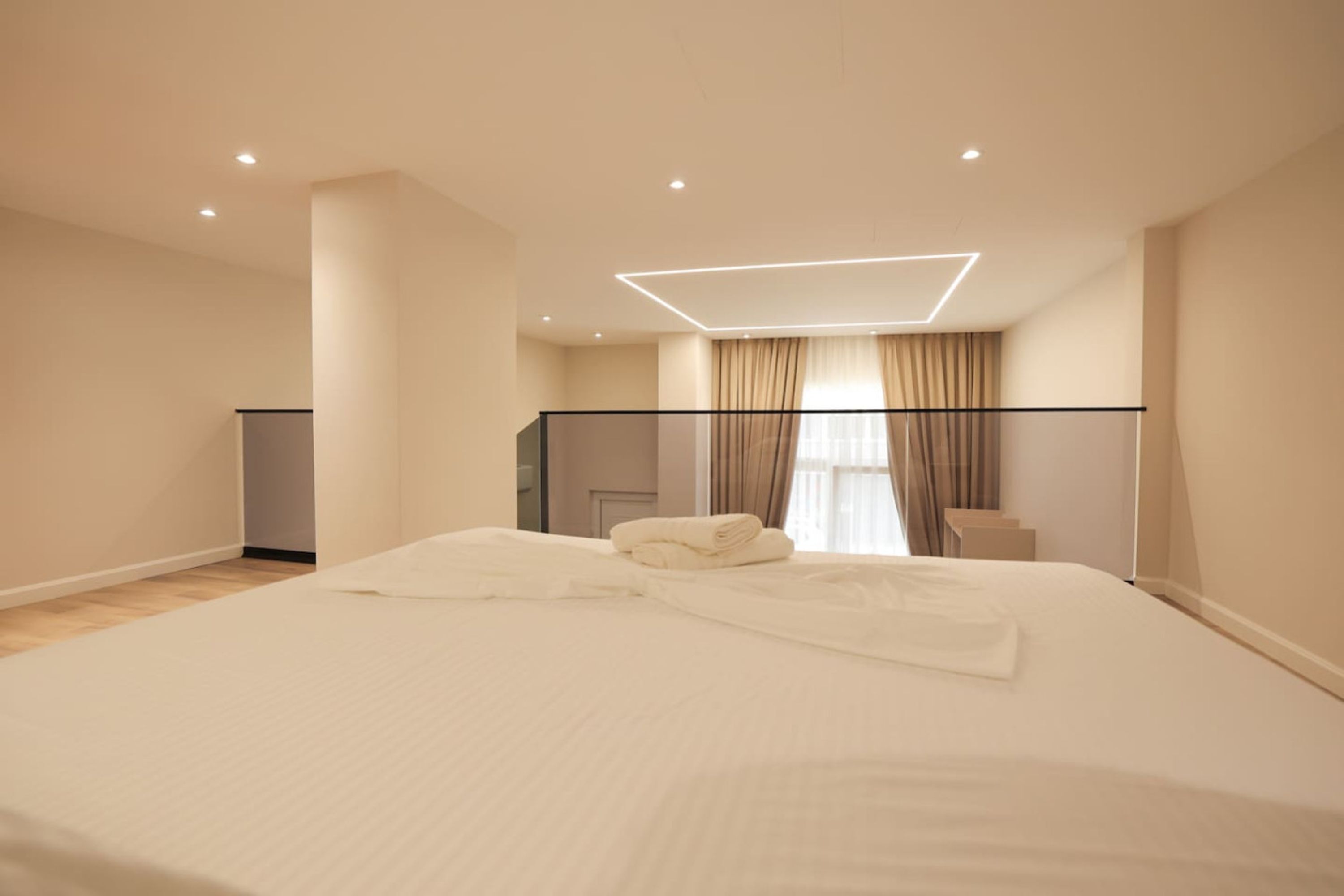 Une chambre d’hôtel moderne dotée d’un grand lit, d’un bureau et d’un balcon.