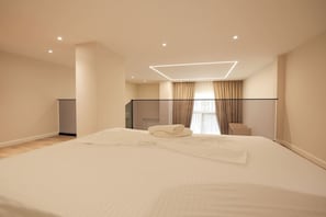 A modern hotel room with a large bed, a desk, and a balcony. - Duplex City 03 in Durrës (Durrës)